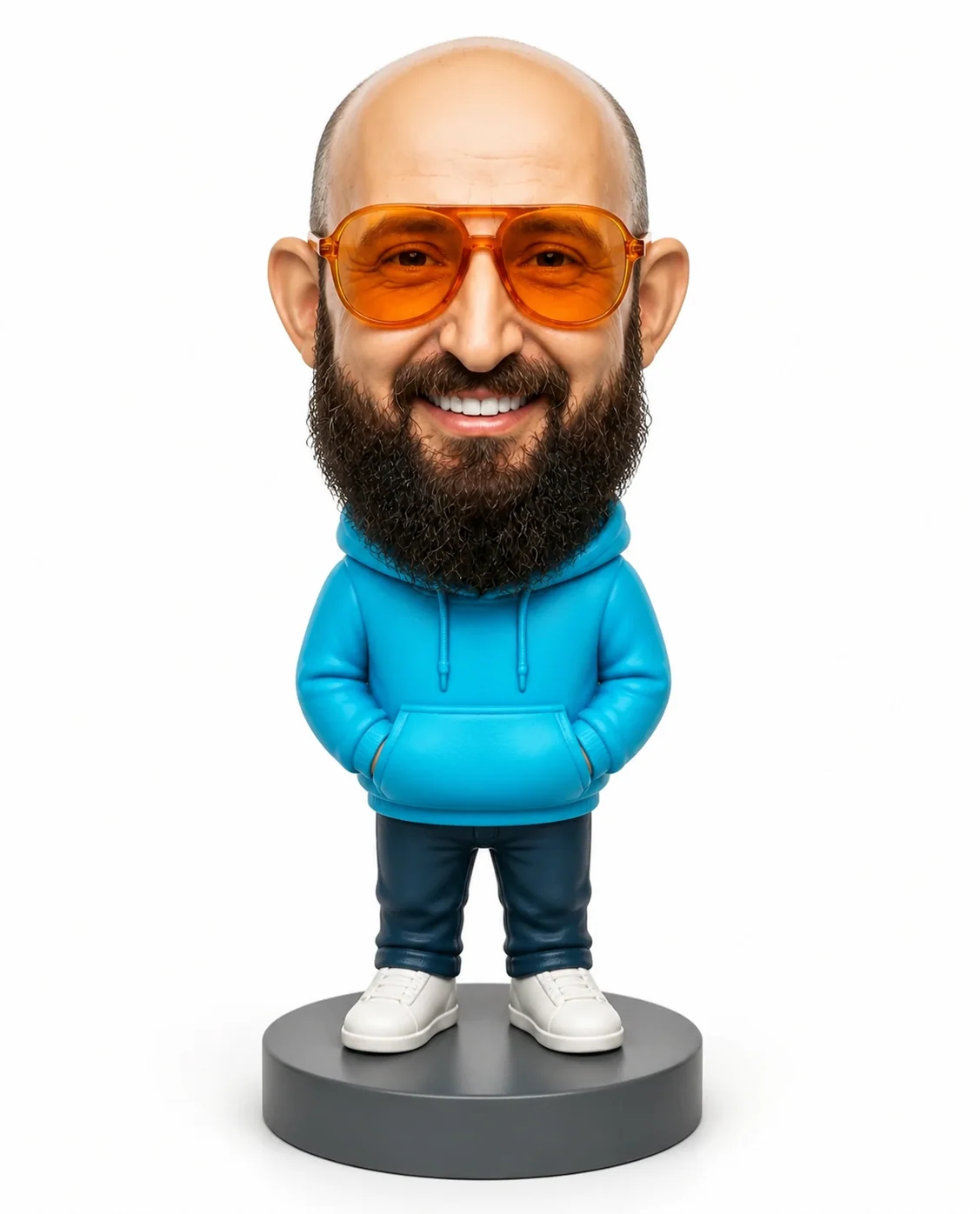 Wackelkopffigur mit großem Kopf, orangefarbener Brille und türkisem Hoodie